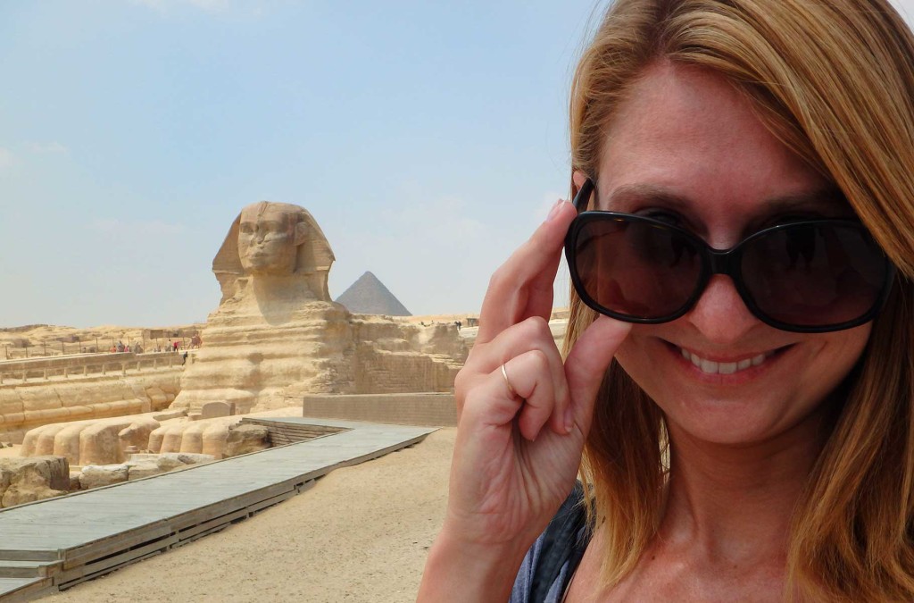 Mulher posa para foto com a esfinge de Gizé ao fundo (Egito)