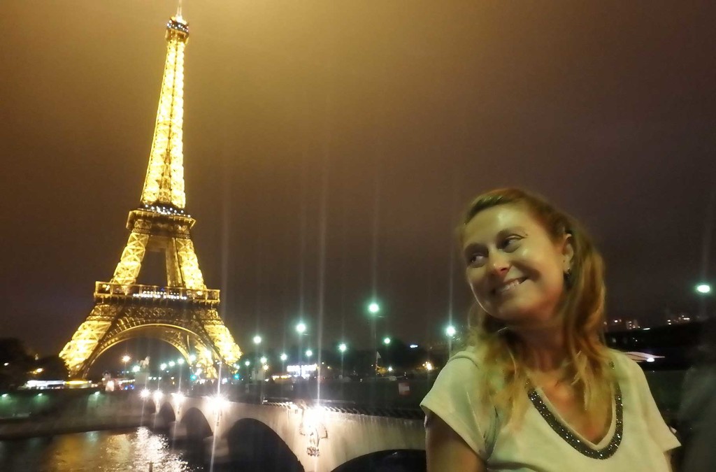 Mulher posa para foto com a Torre Eiffel ao fundo, em Paris (França)