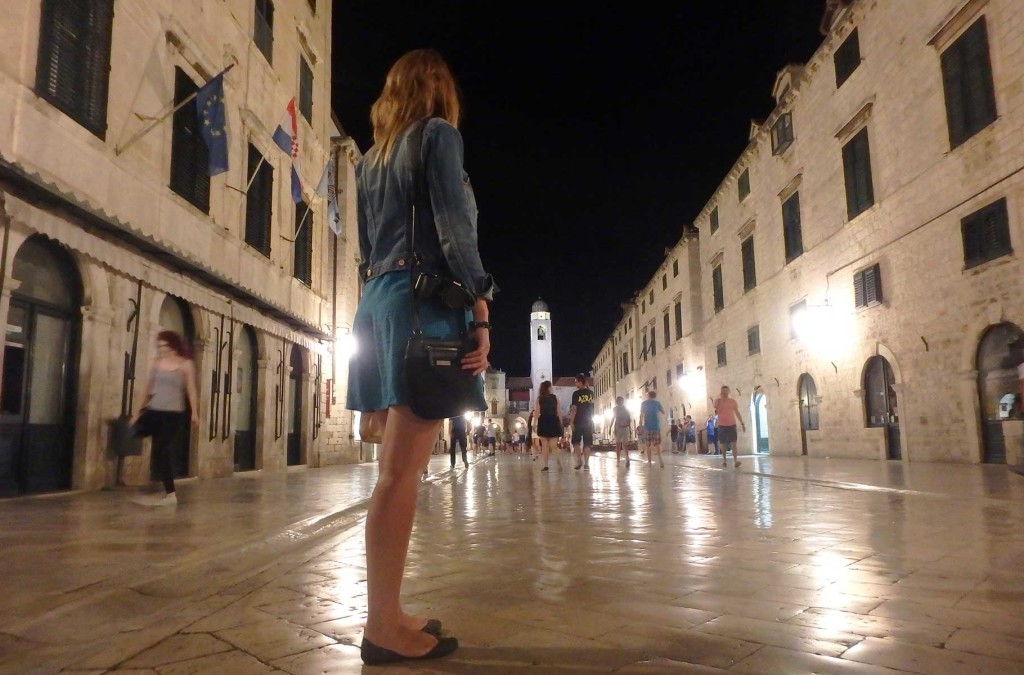 Mulher para à noite nas ruas da cidade medieval de Dubrovnik, na Croácia
