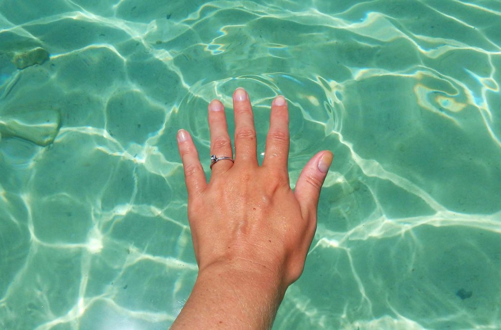 Mulher mostra mão com anel de casamento sobre o mar em Koh Lipe, na Tailândia