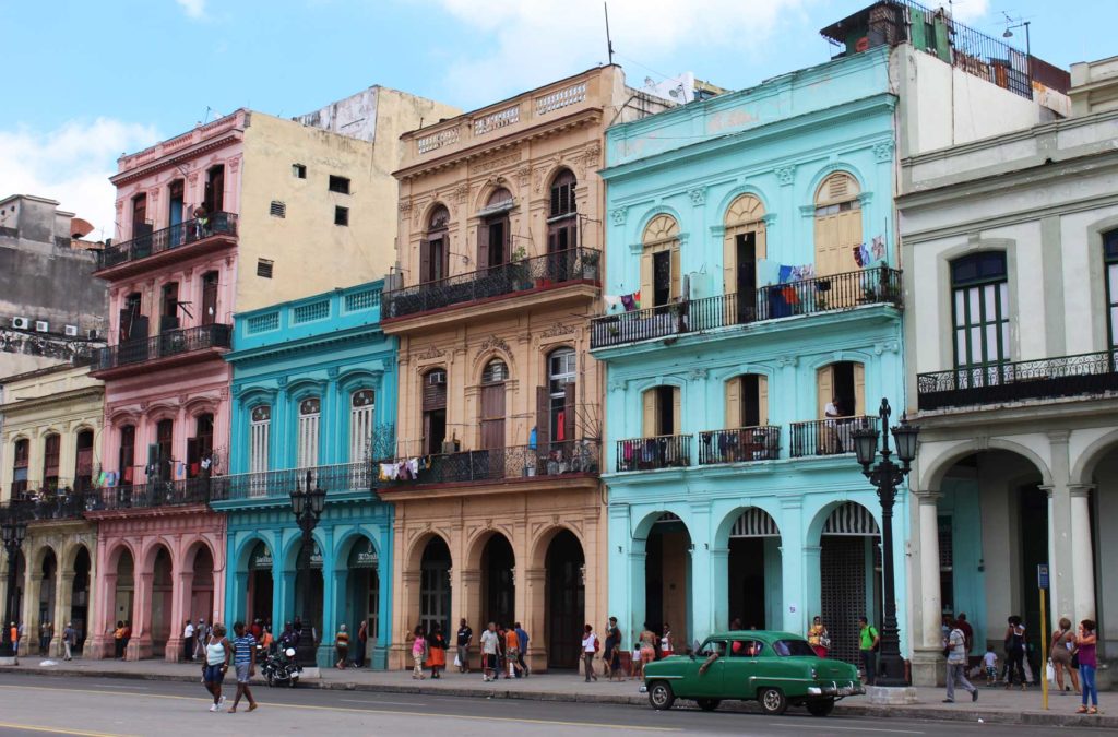 Prédios coloridos e carros antigos nas ruas do centro histórico de Havana, em Cuba