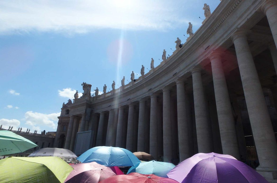 Turistas se protegem com sombrinhas na fila da Piazza San Pedro, em Roma (Itália)