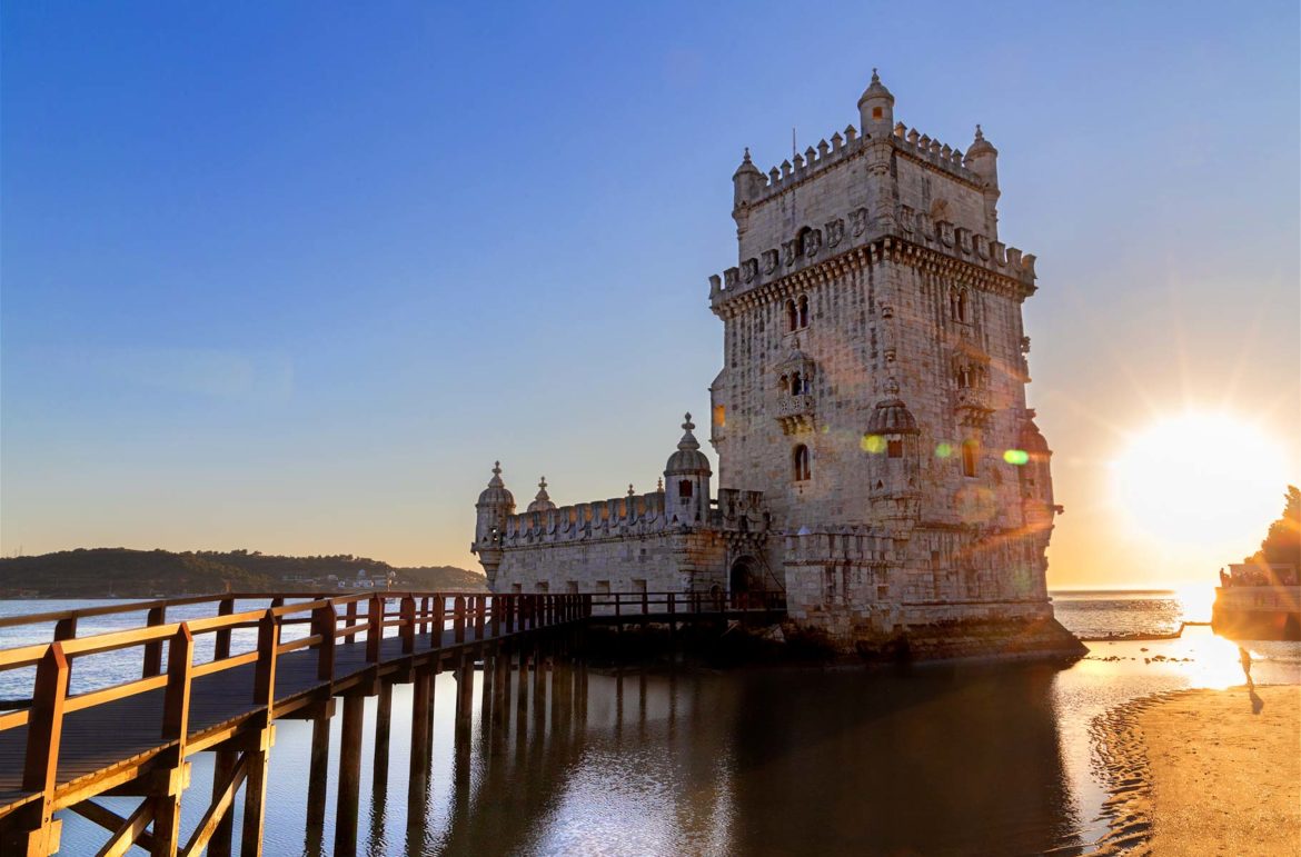 Sol se põe atrás da Torre de Belém, em Lisboa (Portugal)