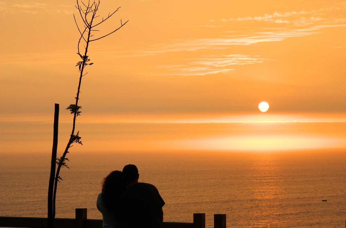 Casal se abraça ao pôr do sol no Parque del Amor, em Lima (Peru)