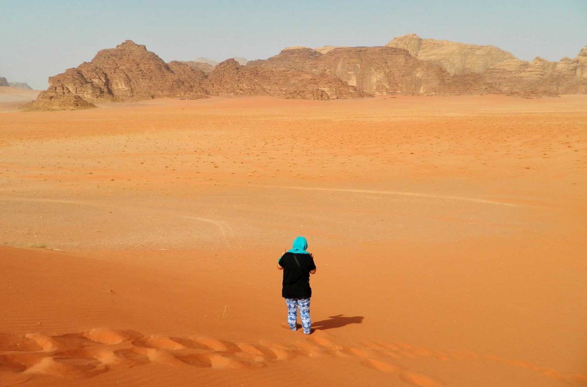 Mulher caminha por duna do Deserto de Wadi Rum (Jordânia)
