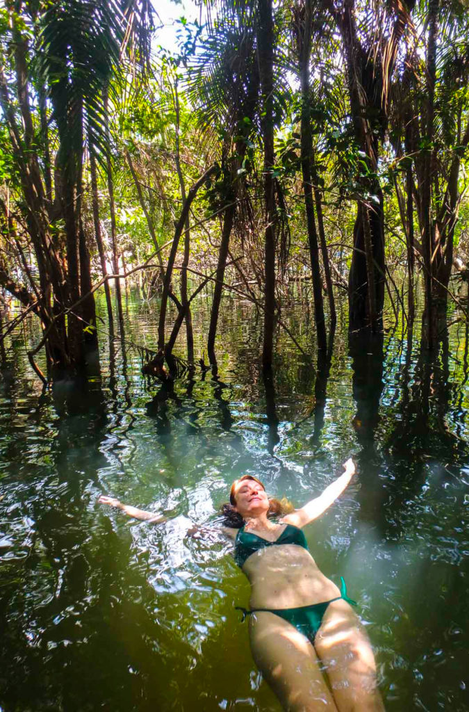 Mulher boia em parte da floresta alagada pelo Rio Tapajós, em Alter do Chão (Brasil)