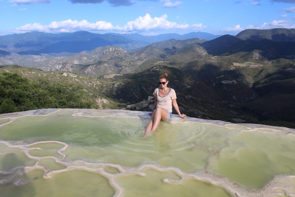 Mulher molha os pés em piscina natural de Hierve em Agua, na região de Oaxaca