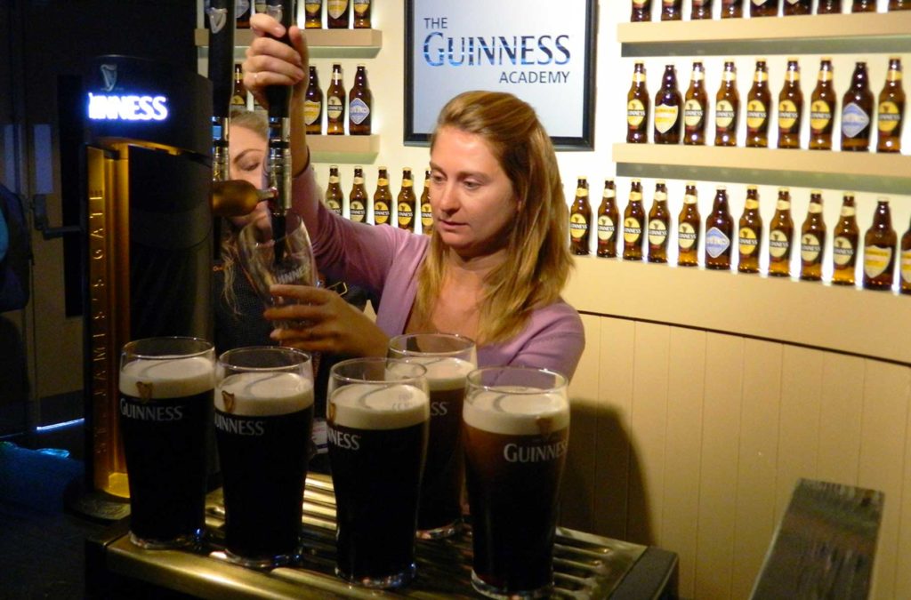 Turista serve cerveja na fábrica da Guinness, em Dublin (Irlanda)