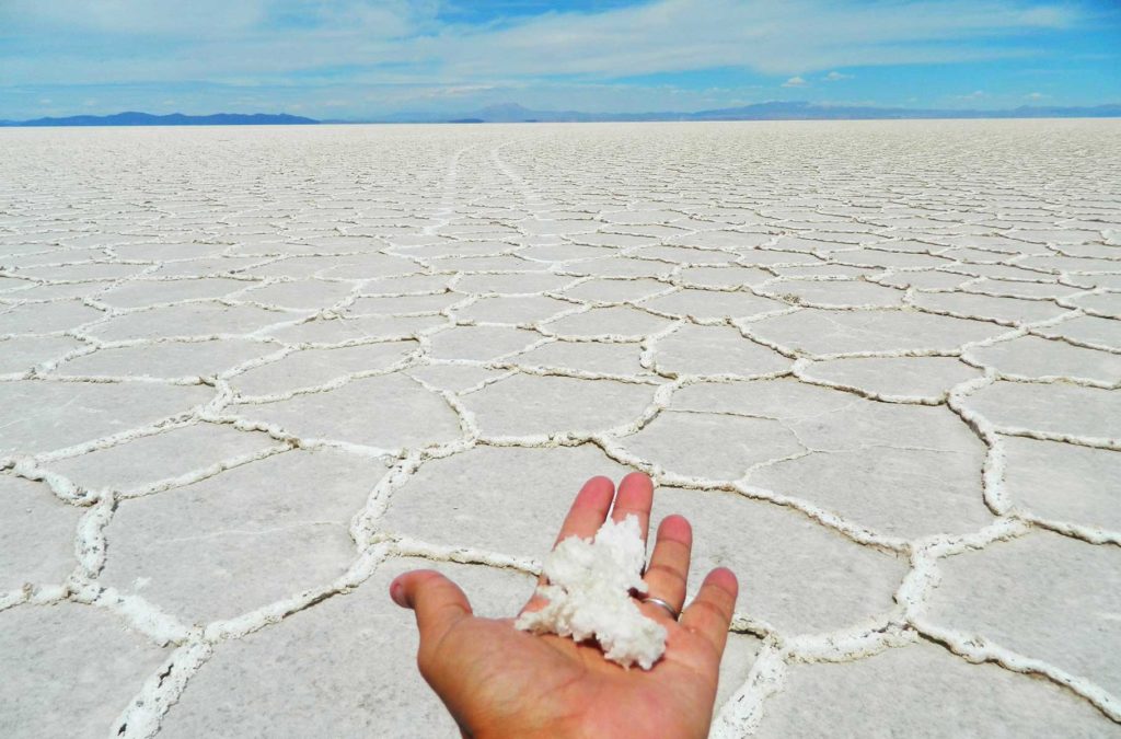 Mão segura um punhado de sal no Salar do Uyuni (Bolívia)
