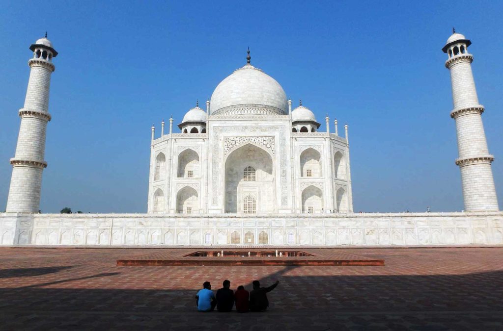 Grupo de visitantes admira fachada lateral do Taj Mahal (Índia)