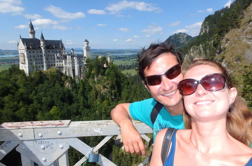 Casal posa para foto com o Castelo de Neuschwenstein ao fundo (Alemanha)