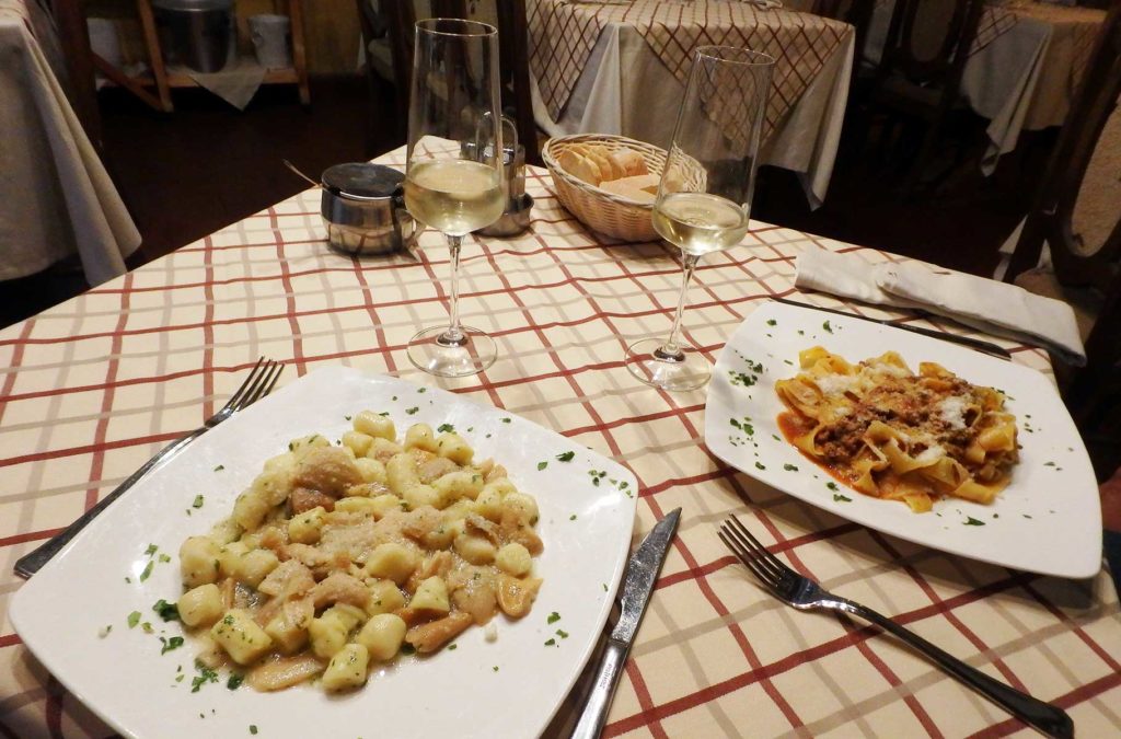 Pratos de massa servidos em mesa de restaurante da cidade de Montalcino (Itália)