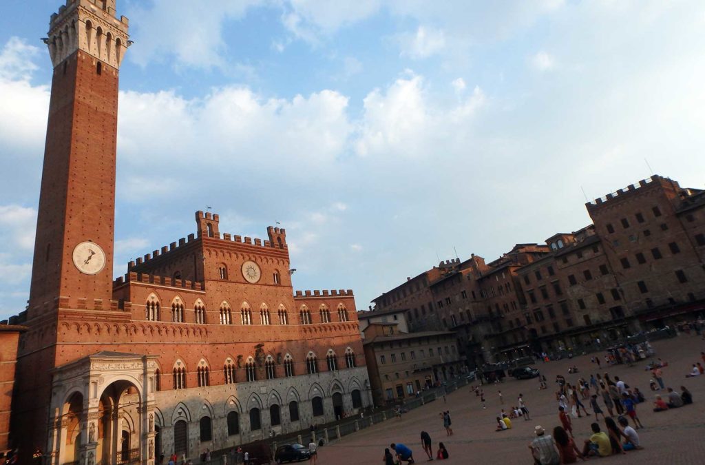 Palazzo Pubblico é iluminado pelo entardecer na cidade de Siena, na Itália