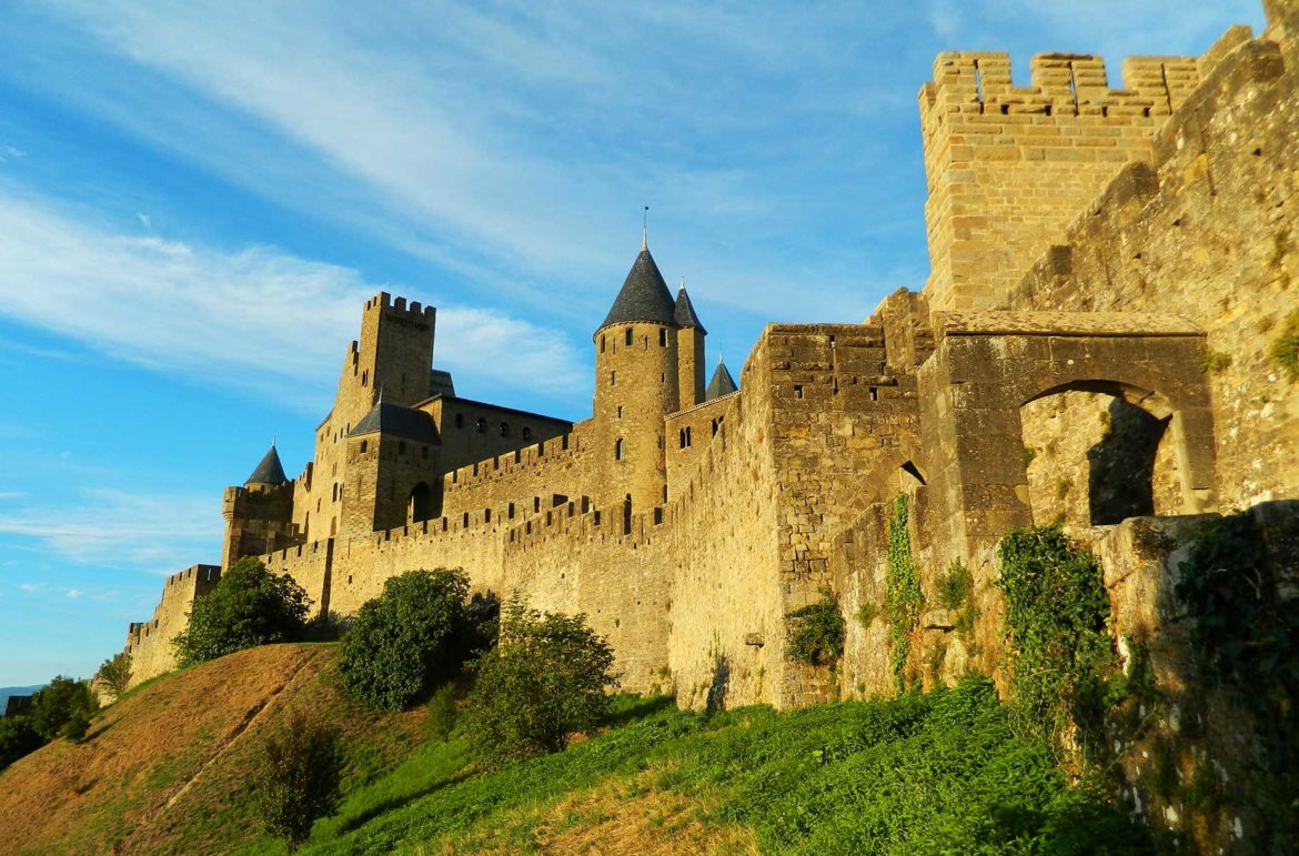 Muralhas medievais da cidade de Carcassonne, na França, são iluminadas pelo pôr do sol