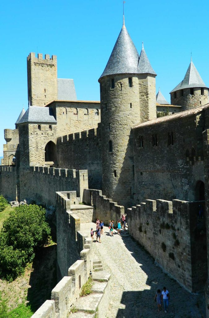 Turistas passeiam pelas muralhas medievais da cidade de Carcassonne, na França