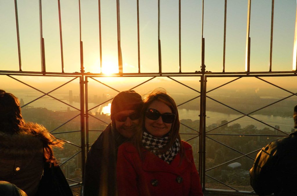 Casal posa para foto ao pôr do sol no 86º andar do Empire State, em Nova York (EUA)
