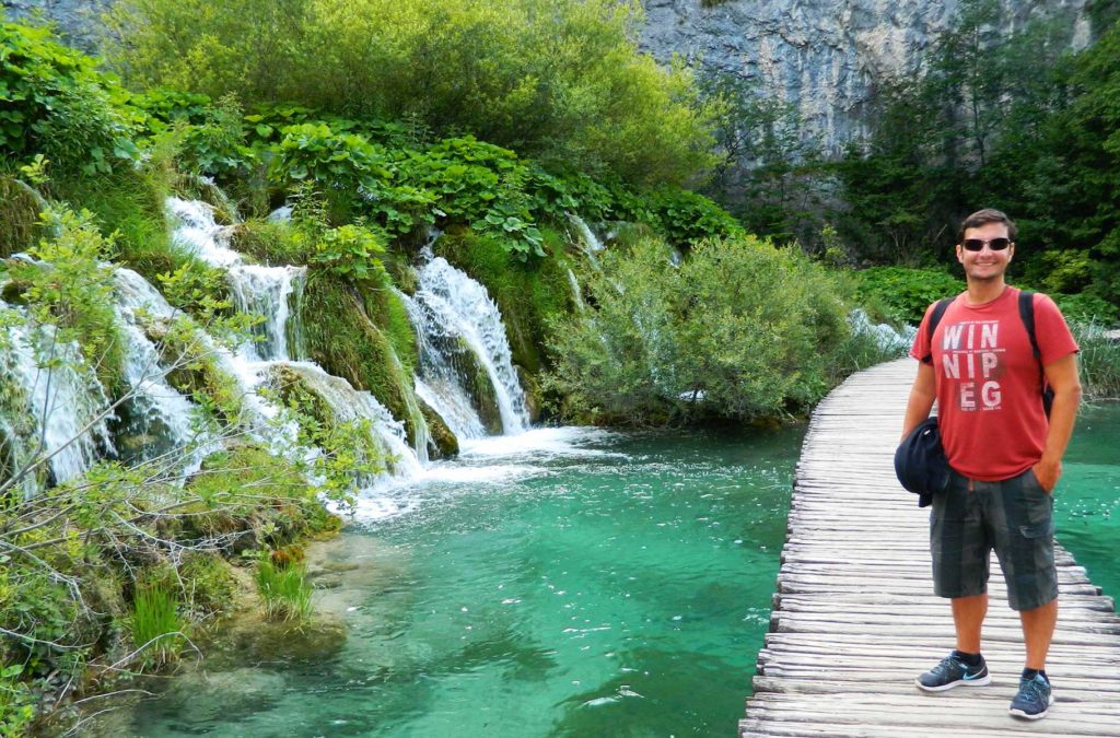 Turista posa para foto nas passarelas de madeira sobre os Lagos Plitvice