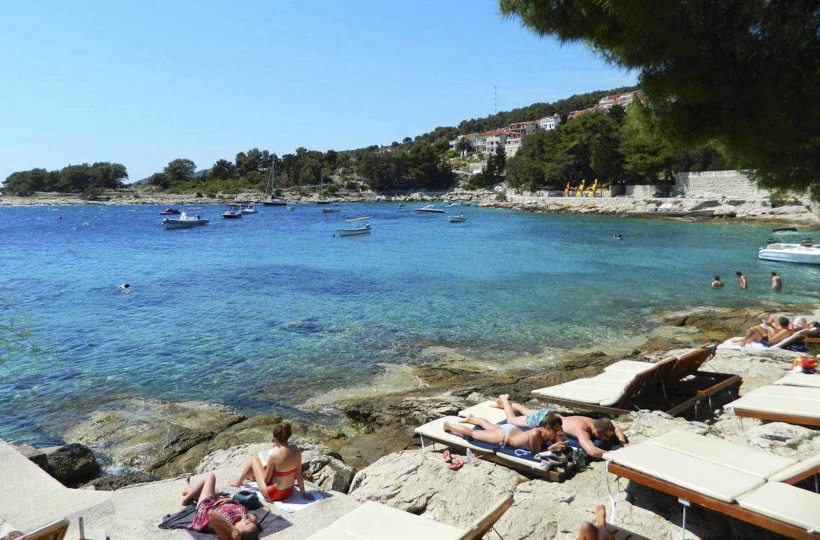 Visitantes tomam banho de sol nas pedras em Praia Hula Hula, na Ilha de Hvar (Croácia)