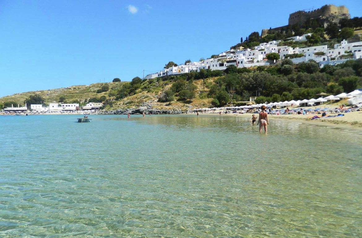 Praia principal da Baía de Lindos, na Ilha de Rhodes (Grécia) com a Acrópole ao fundo