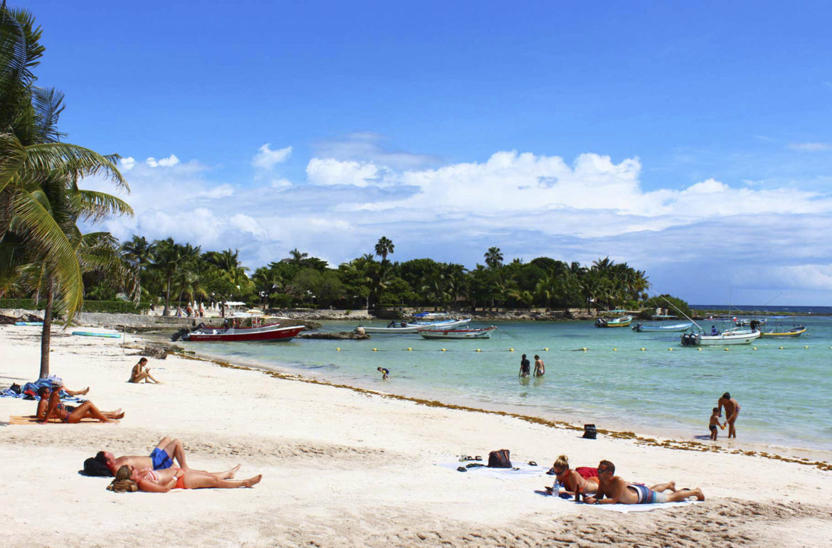 Visitantes tomam banho de sol e de mar na Praia de Akumal, na Riviera Maia (México)