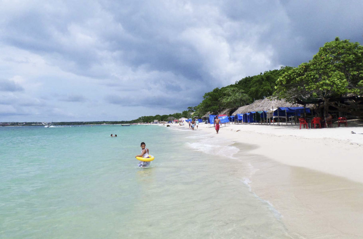 Criança entra no mar na Playa Blanca, em Cartagena (Colômbia)