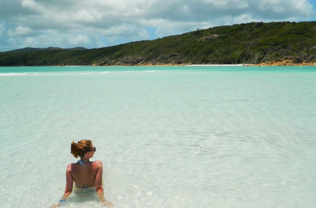 Mulher toma banho de mar em Whitehaven Beach, na Austrália
