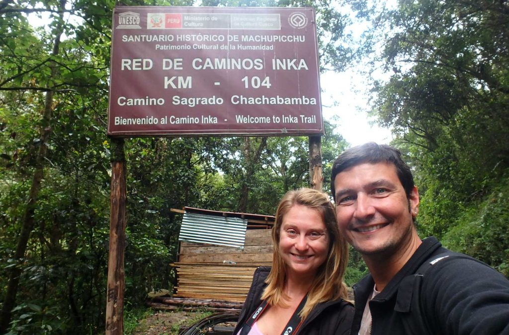 Casal de turistas posa com a placa de indica o início da Trilha Inca