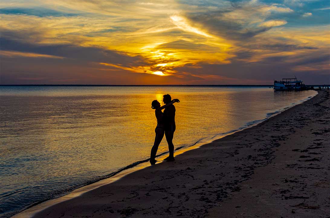 Casal fica mostrando puro amor um ao outro ao pôr do sol