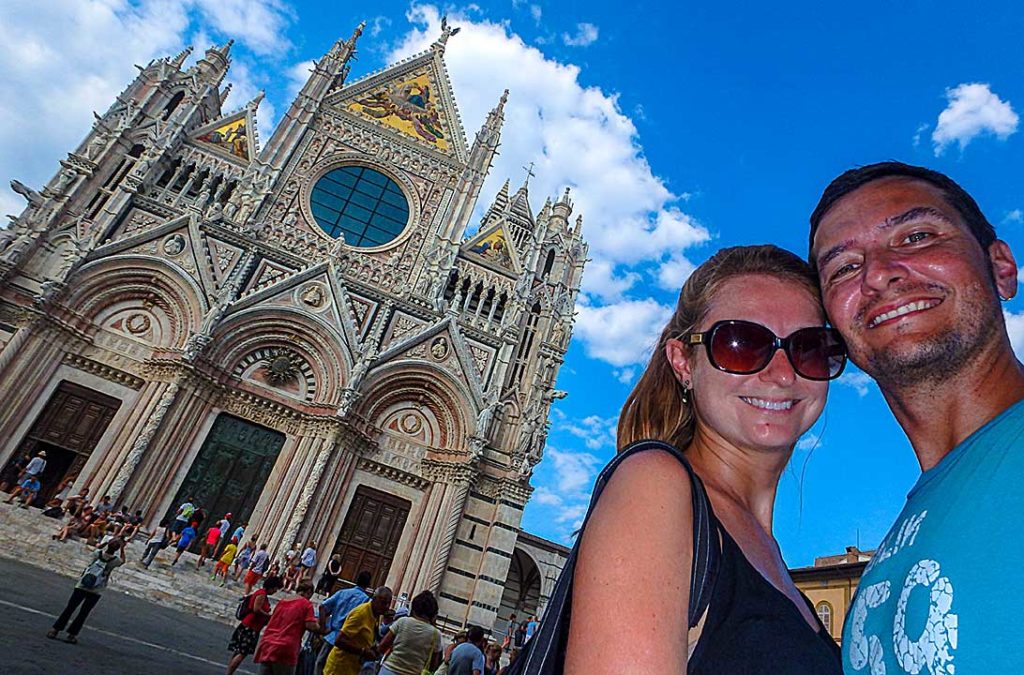 Casal posa para foto com o 'Duomo' de Siena ao fundo, na Itália