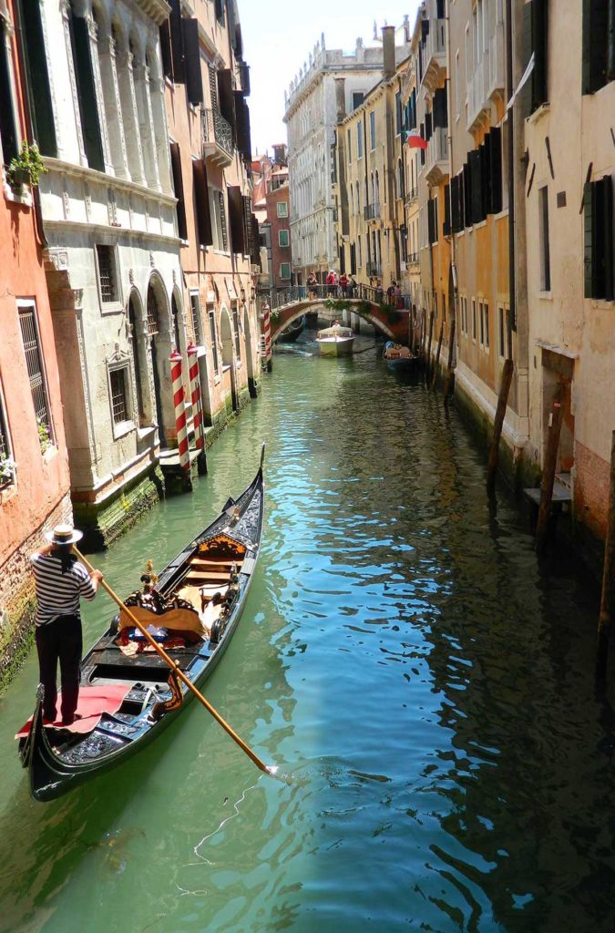 Gôndola com casal é conduzida por canal de Veneza, na Itália