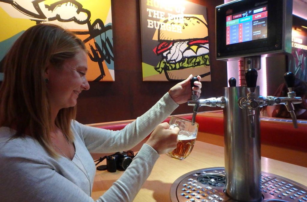 Mulher serve caneco de cerveja em bar de Praga, na República Tcheca
