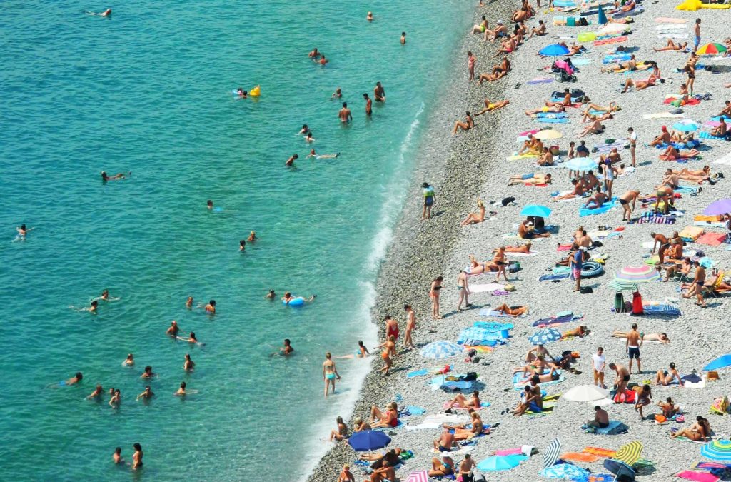 Multidão lota a beira da praia de Nice, na França, durante o verão