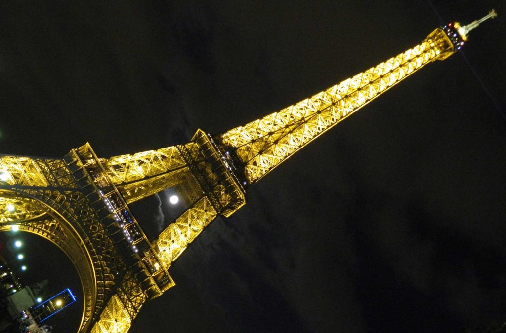 Lua aparece entre a estrutura da Torre Eiffel