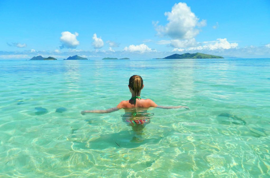 Mulher nada na Sunset Beach, em Mana Island (Fiji)