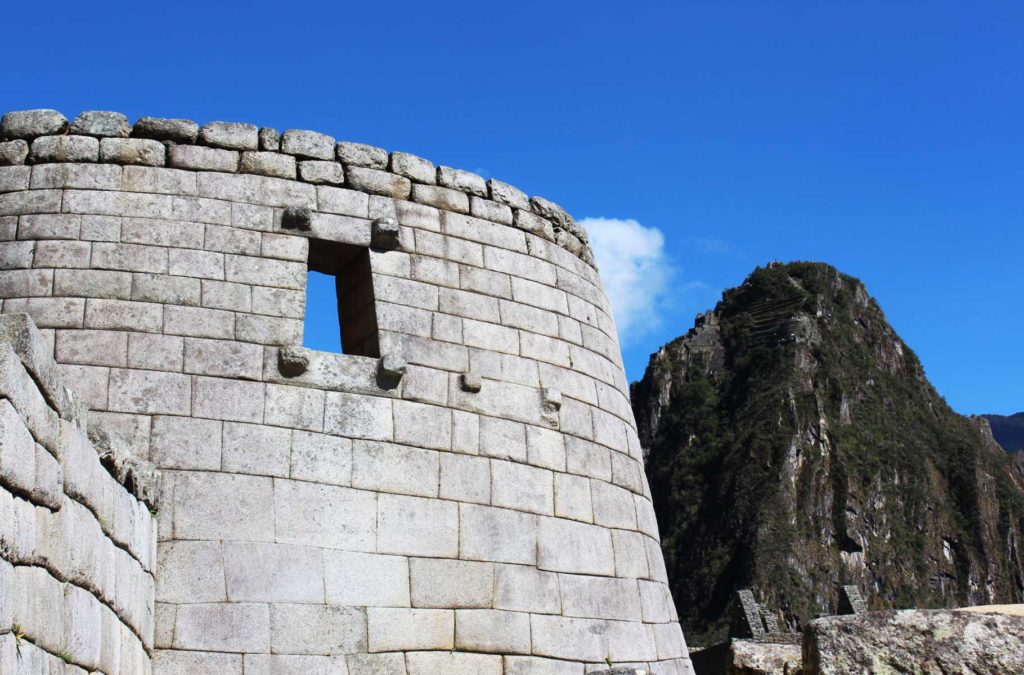 As ruínas do Templo do Sol com a Montanha Huayna Picchu ao fundo