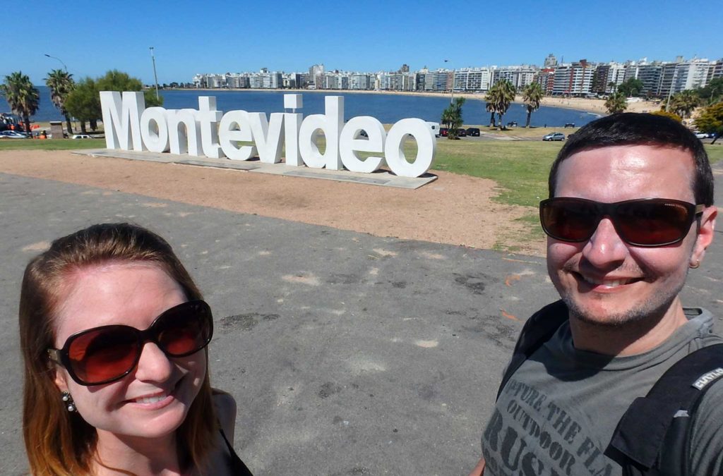 Casal de turistas posa em frente ao letreiro 'Montevideo', na Praia de Pocitos