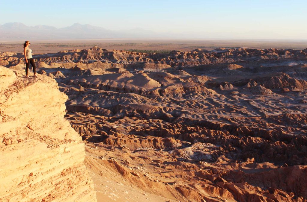 Mulher posa para foto na beira de penhasco no Deserto do Atacama, no Chile