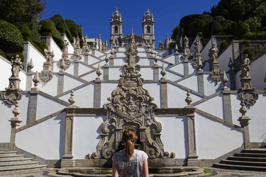 Mulher de costas admira a escadaria do Santuário de Bom Jesus do Monte (Portugal)