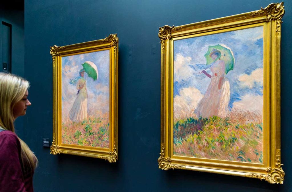 Mulher admira quadros de Monet no Museu d'Orsay, em Paris (França)