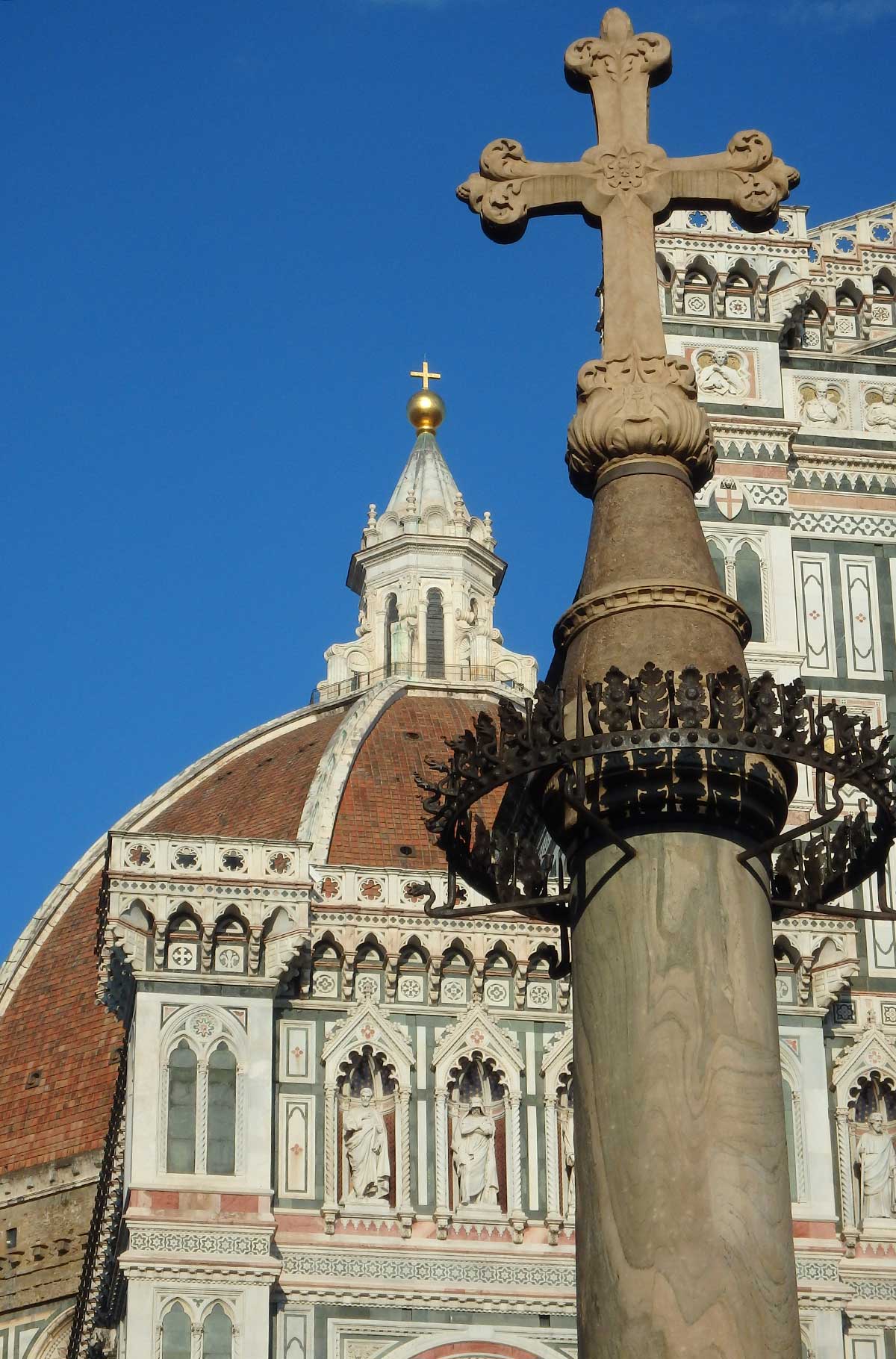 Cruz em frente à fachada do Duomo de Florença, na Itália