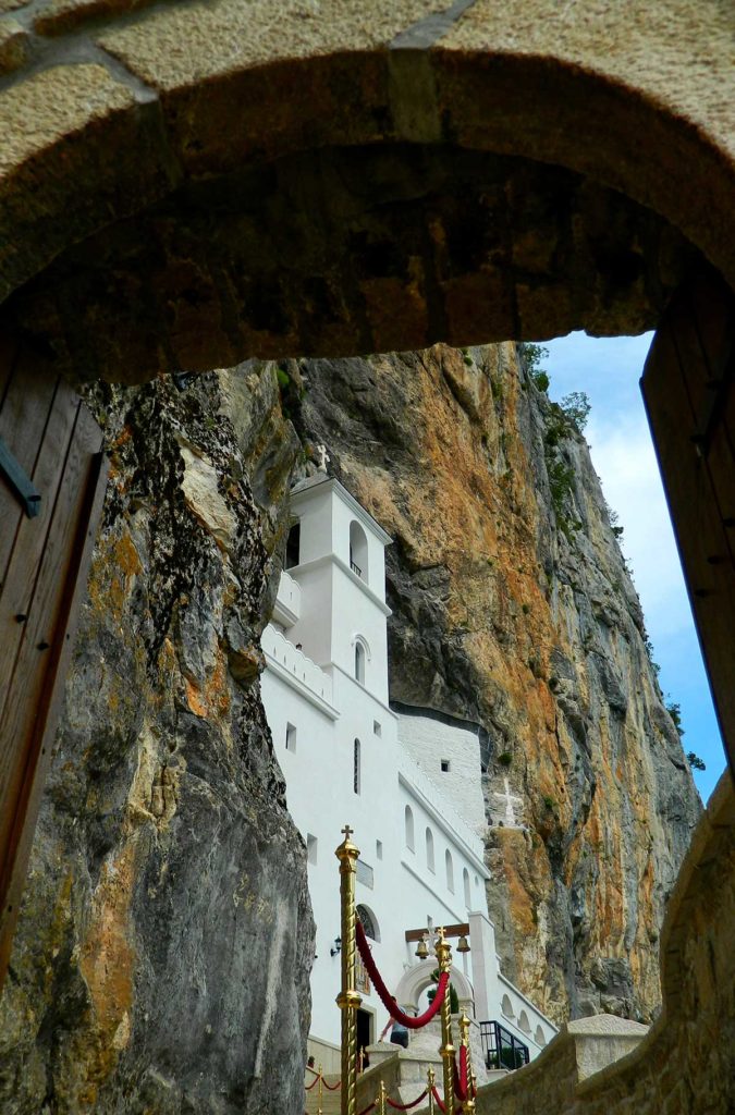 Mosteiro de Ostrog, visto através do portal de entrada, é atração de graça em Montenegro