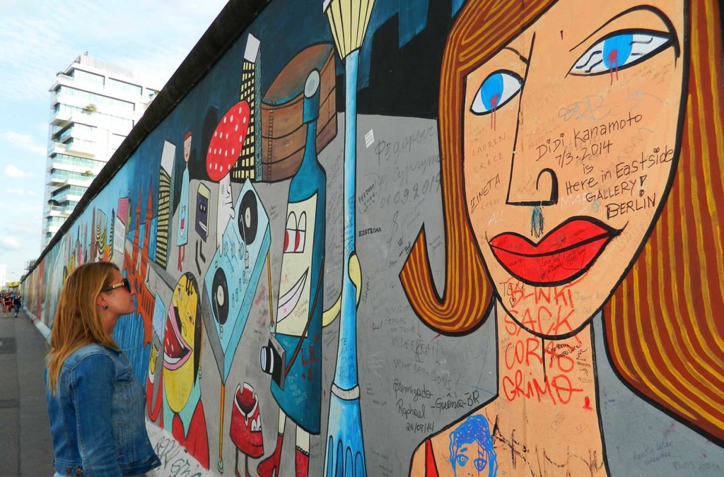 Mulher admira os grafites sobre o Muro de Berlim na East Side Gallery (Alemanha)