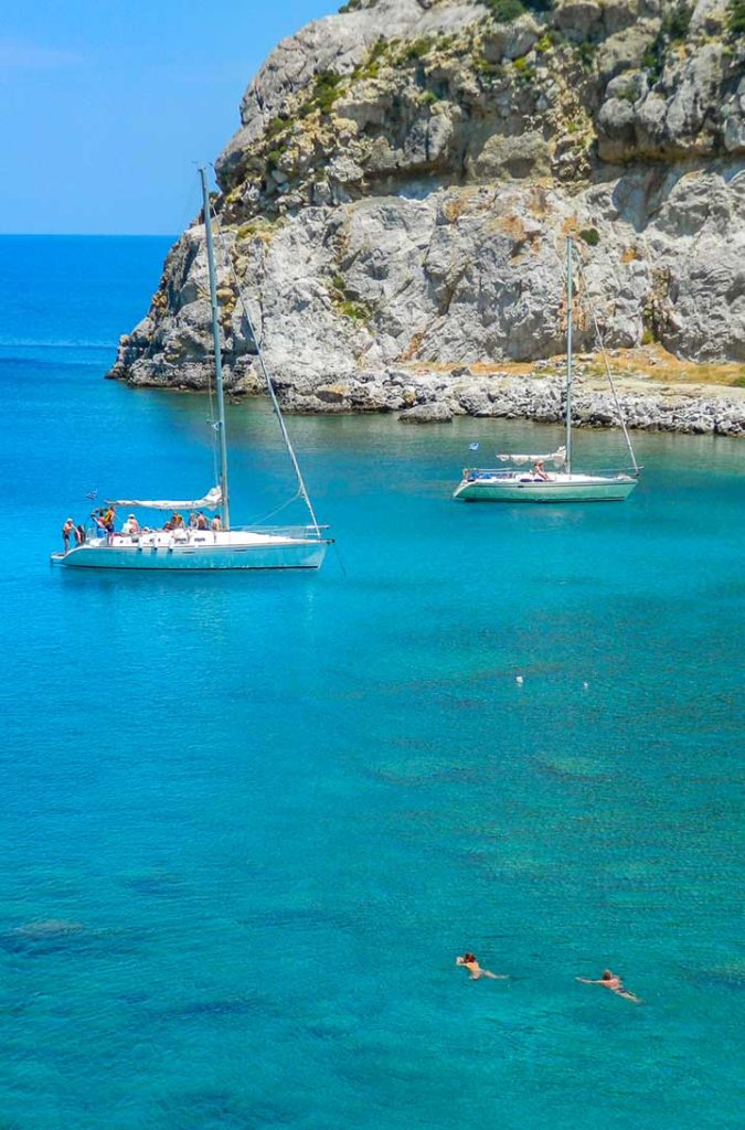 Barcos ancoram para turistas nadarem na Baía de Ladiko, na Ilha de Rhodes