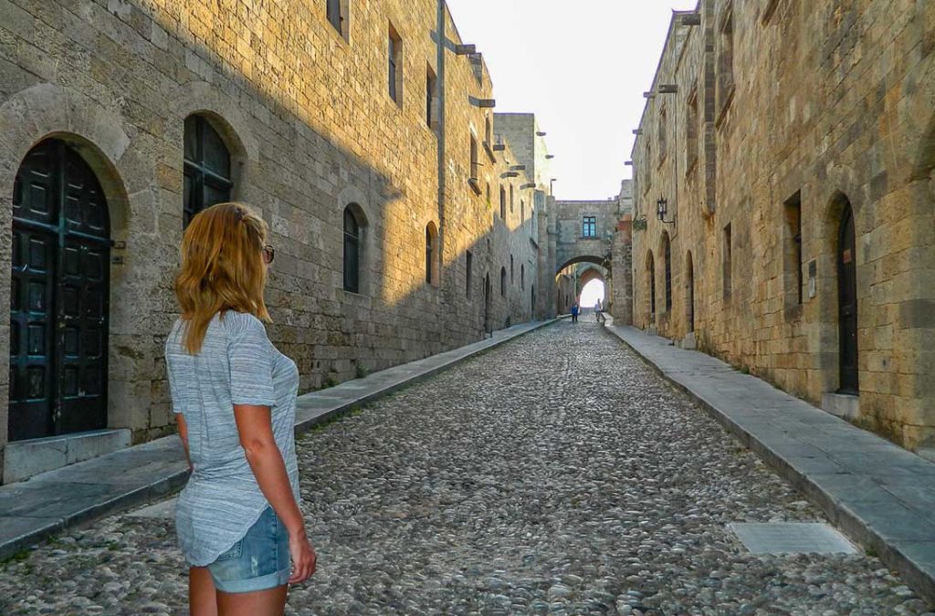 Mulher posa para foto na Rua dos Cavaleiros, em Rhodes