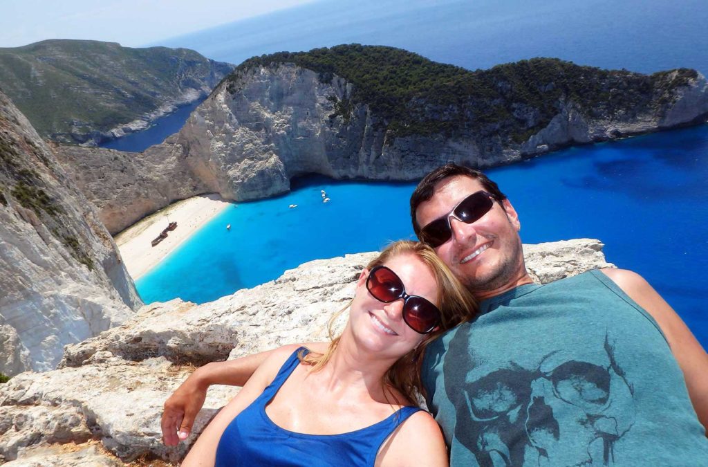 Casal posa para foto nos rochedos sobre a Praia de Navagio, em Zakynthos (Grécia)
