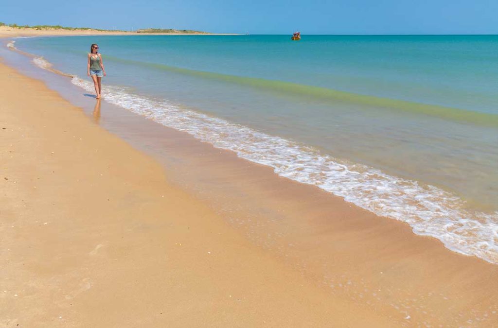 Mulher caminha pela praia de Galinhos (Brasil)