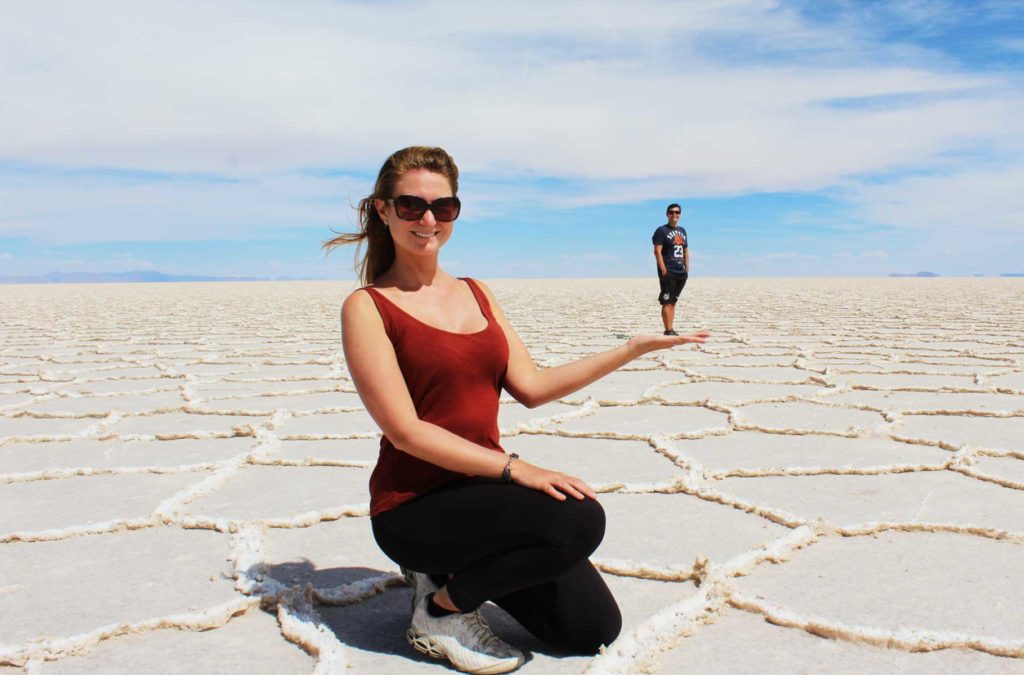 Casal tira foto brincando com a perspectiva no Salar do Uyuni (Bolívia)