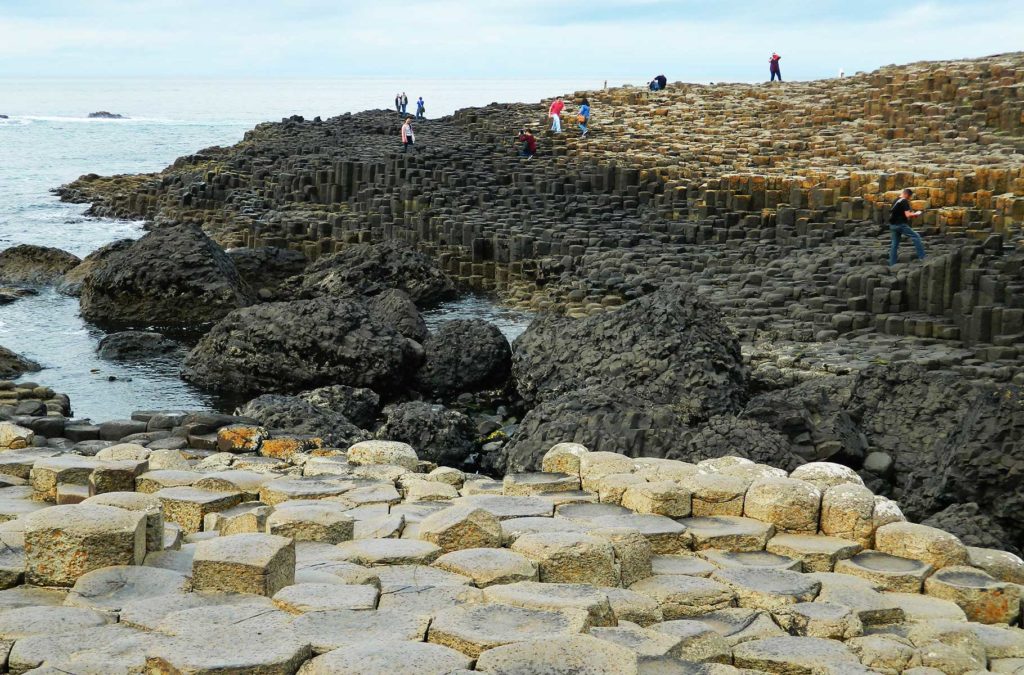 Turistas sobem nas pedras da Giant's Causeway (Reino Unido)
