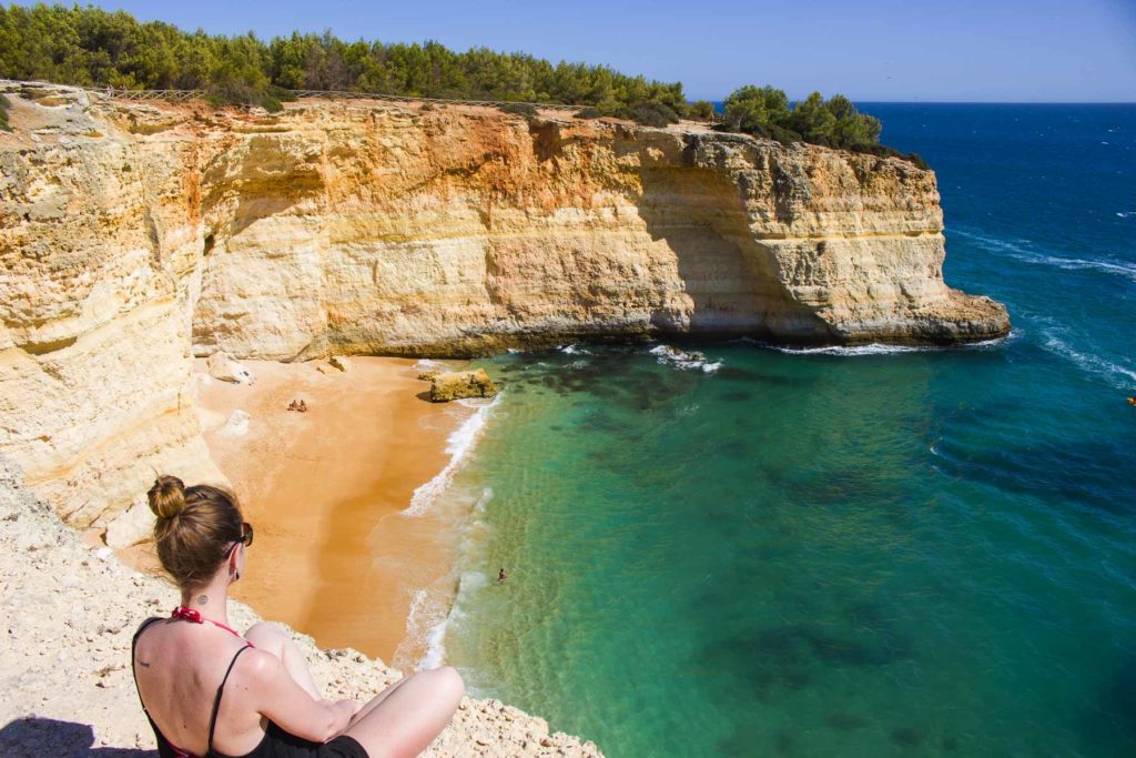 Mulher admira praia de Benagil, no Algarve (Portugal)