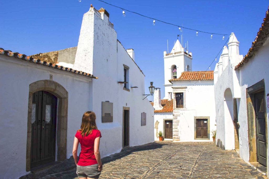 Mulher caminha pelo vilarejo medieval de Monsaraz